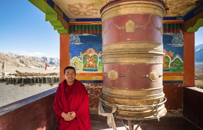 Un monaco Buddhista tibetano si fa fotografare al Monastero Thiksay, in Ladakh