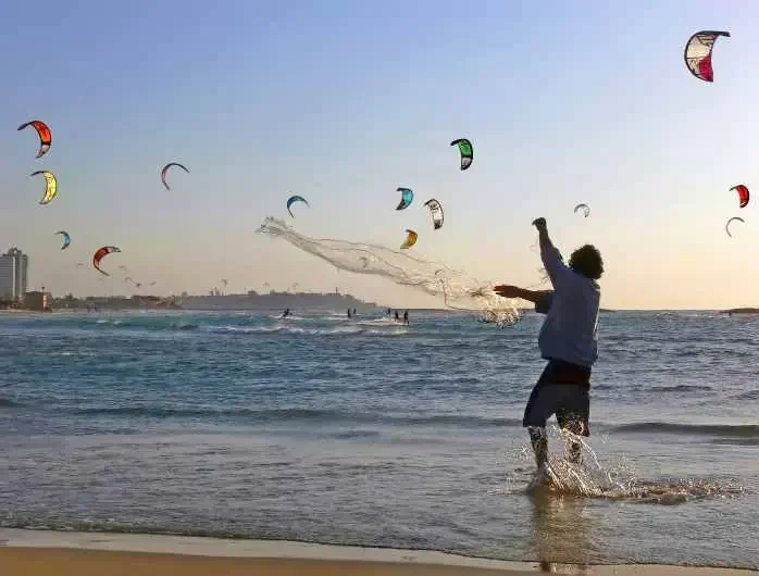 Fisherman throwing a seine in the sea and surfers; Shutterstock ID 59782876; Brand (KAYAK, Momondo, Any): MMD