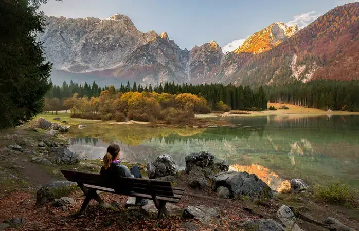 Young female is enjoying autumn colors at Laghi di Fusine in Italy; Shutterstock ID 776290393