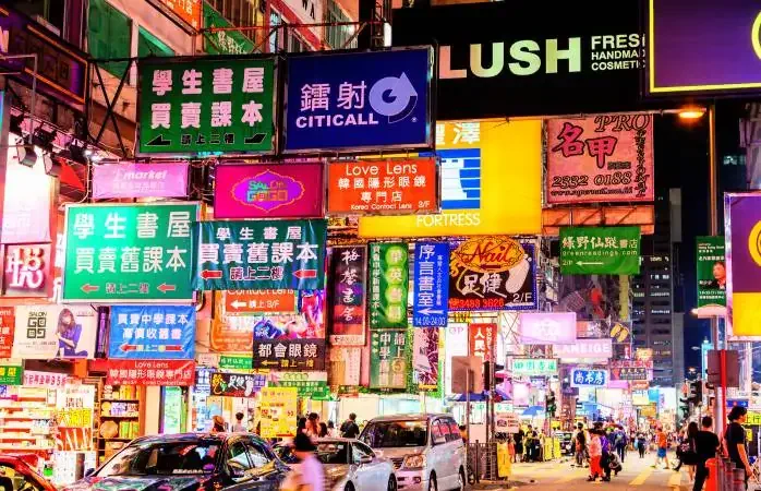 HONG KONG, JULY 10, 2017: Colorful billboard neon signs hang precariously on buildings along Nathan Road in Mongkok, one of the busiest and most popular commercial areas in Hong Kong and a favorite place for visitors and locals to hang out and explore.