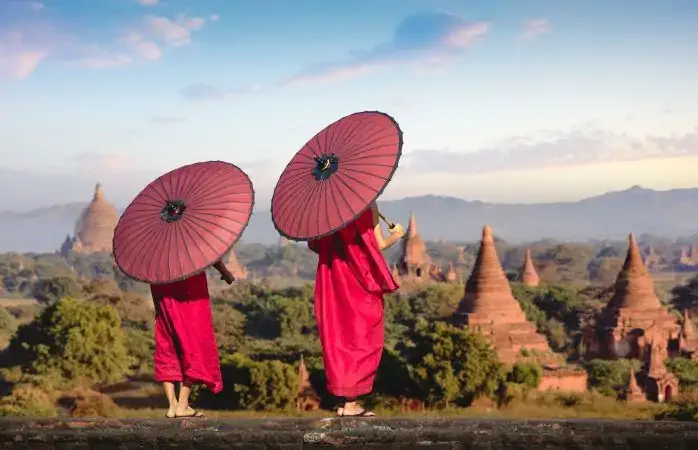 Two novices standing with holding red umbrella, Bagan Mandalay Myanmar